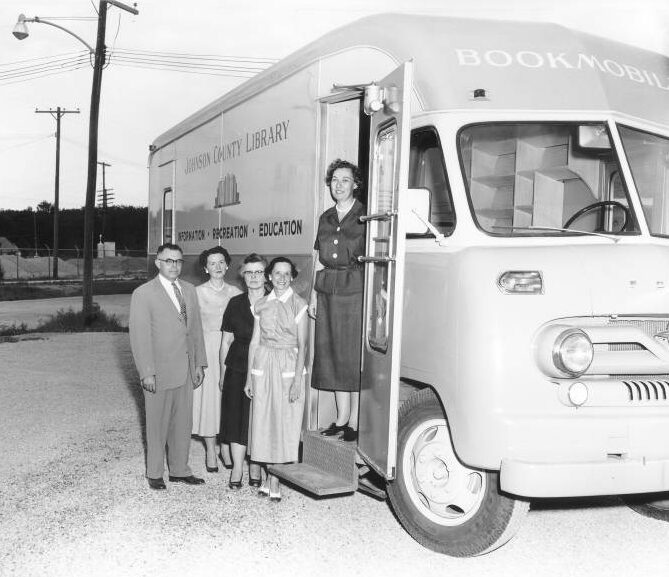 Old photograph of bookmobile with librarian and library board members