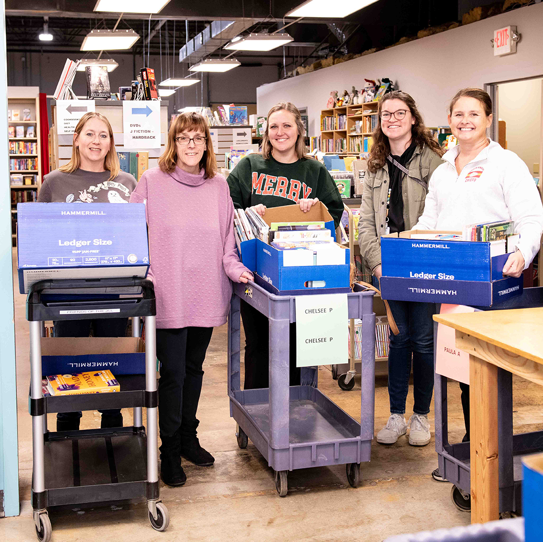 Local Title 1 Teachers accepting a book donation from the Friends provided by a generous donor.